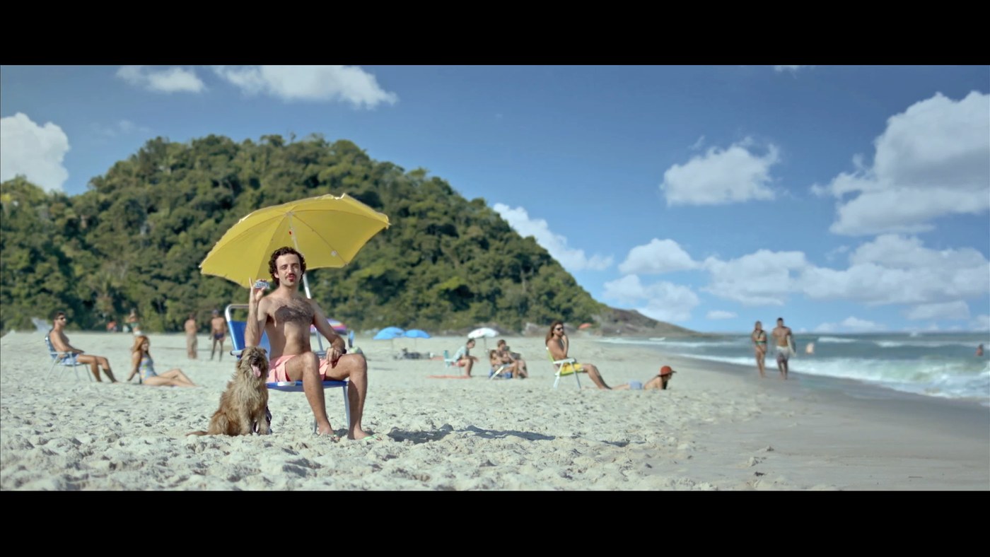 Referência de personagem sob sombreiro amarelo na praia